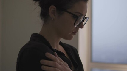 Anxious woman feeling scared, hugging shoulders trying to calm down, victim of workplace harassment, gender or racial discrimination, humiliation of women's rights