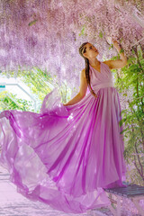Fototapeta premium Woman wisteria lilac dress. Thoughtful happy mature woman in pur