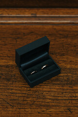 Golden wedding rings in their black box on a wooden table