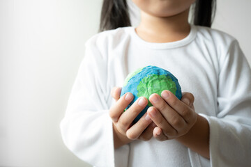 Asian kid holding earth sign of environment friendly concept. Little hands saving the world.