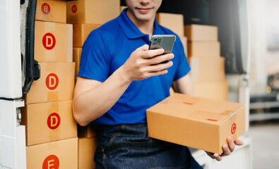 Smiling delivery man standing in front of his van with Holding Box and tablet, smartphone delivery home and shipping ..