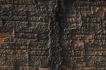 Brick wall, with roughcast concrete, gray in the afternoon sun.