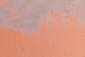 Wall with graffiti, orange, with concrete putty to fix imperfections.