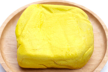 Yellow tofu on wooden plate