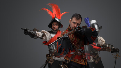 Portrait of isolated on grey background conquistador with rifle and soldier pointing finger.