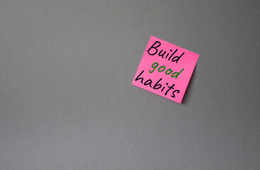 Build good habits symbol. Concept words Build good habits on pink steaky note. Beautiful grey background. Business and Build good habits concept. Copy space.