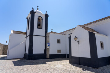 Beautiful church and square of the village of Aldeia Nova with the white typical facade in a sunny...