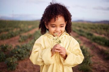 Children, farm and a girl smelling flowers outdoor in a field for agriculture or sustainability....