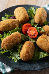 Traditional spanish fried croquettes on wooden table. Close up