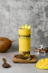 Mango-Kokos Smoothie auf hellgrauem Hintergrund