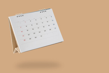 White paper desk calendar flipping page isolated on brown background - obrazy, fototapety, plakaty