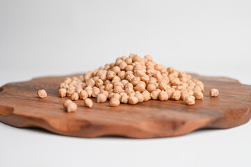 A pile of organic chickpeas on a wooden stand. Side view