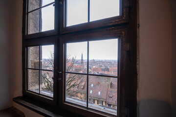 Fototapeta na wymiar An ancient window overlooking the tiled roofs of Nuremberg, Germany
