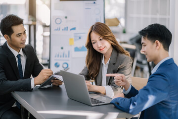 Businessmen write project ideas and use laptops to edit papers for brainstorming sessions with partners in the office.