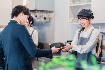 Obraz premium スマホでタッチ決済をする男性