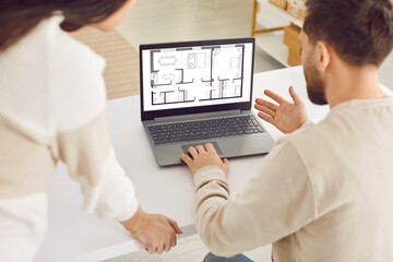 Family couple or architect coworkers looking at blueprint on laptop. Young man and woman using...