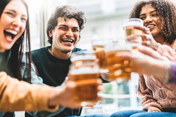 Group of happy diverse friends toasting beer glasses at brewery pub-Young smiling people enjoying...