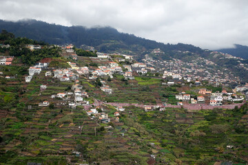 Fototapeta na wymiar A typical view across Madeira above Funchal, showing patchwork of fields and houses with tunnels