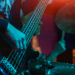 The bass guitarist plays the bass guitar. Dark key. Selective focus