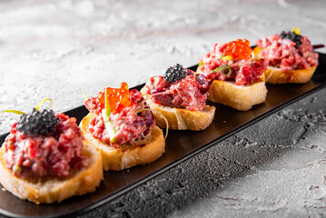 bruschetta with salmon and tuna fish tartare on plate