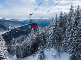 Modern ski lift gondola against snowcovered fir forest and mountains © sandsun
