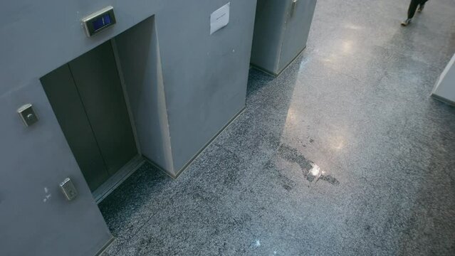 Adult man tries call broken elevator at modern office building, pushes call button and goes to stairway. Observation and CCTV technologies. Concept of social safety. Privacy. Security camera shooting.