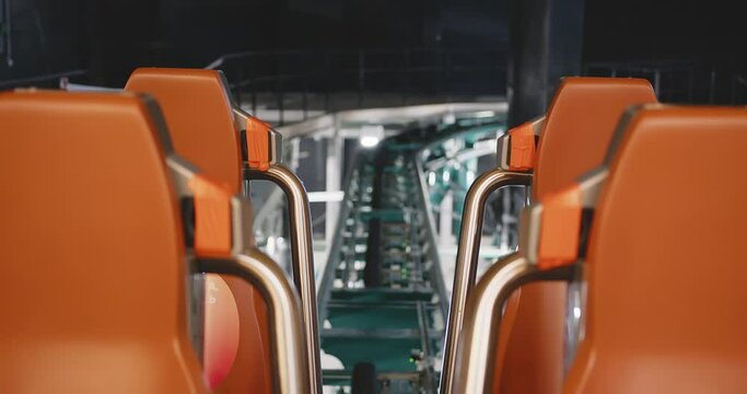 chairs on a rollercoaster trailer. rollercoaster rails. Bright orange armchairs.