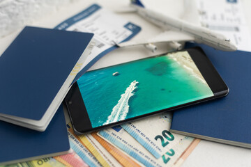 a passport, a flight ticket, differnt currencys on a white surface.