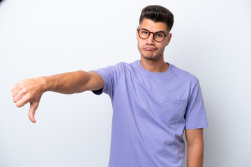 Young caucasian man isolated on white background showing thumb down with negative expression