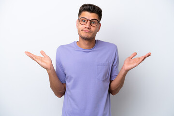 Young caucasian man isolated on white background making doubts gesture