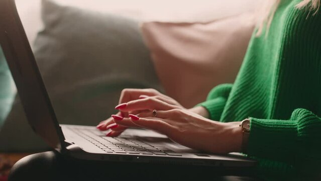 journalist freelancer typing text on laptop, closeup of hands on keyboard, computer on female knees