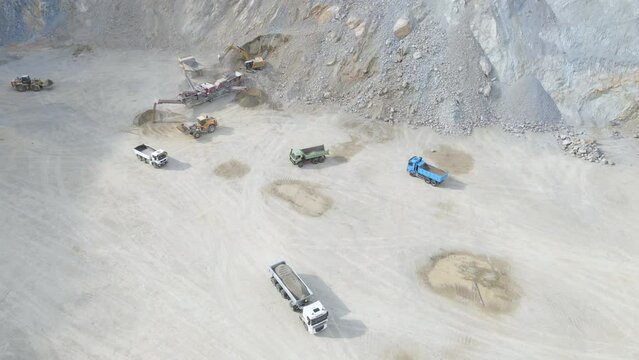 Aerial View of Heavy Machines and Loading Trucks in Stone Quarry, Transporting Gravel and Sand. Drone Shot
