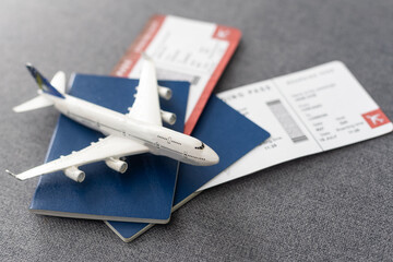 Plane tickets, passports and toy plane on table