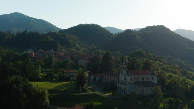 Aerial View Of Scenic Italian Village Located Beside Forested Hills In Arola, Italy. Slow Circle Dolly 