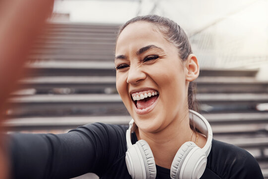 Woman, face and selfie with headphones and exercise in city, happy in Brazil, laughter and fitness outdoor. Runner, cardio and happiness in picture, health and wellness with active lifestyle