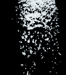 Salt flying explosion, crystal white grain salts explode abstract cloud fly. Beautiful complete seed salt splash in air, food object design. Selective focus freeze shot black background isolated