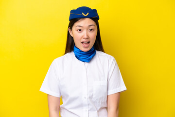 Airplane Chinese woman stewardess isolated on yellow background with surprise facial expression