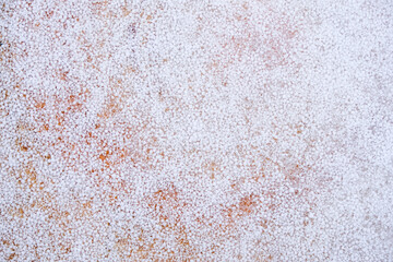 Graupel or snow pellets. Soft orange backdrop. Copy space.