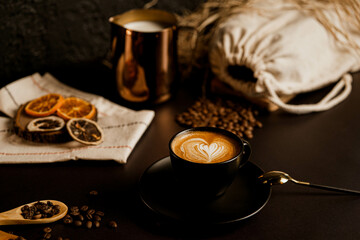 It consists of dried fruit, milk, a coffee with coffee art and coffee beans on a black background.