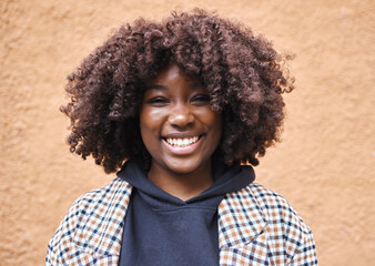 Black woman, portrait and afro on wall background in city, urban town or fun in Kenya. Happy young...