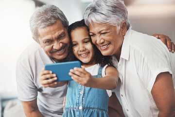 Naklejka na ściany i meble Love, happy and girl taking selfie with her grandparents for social media in modern family home. Happiness, smile and excited child taking picture with grandmother and grandfather at house in Mexico.