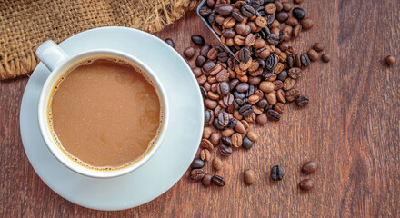 cup of coffee and coffee beans in a sack on  Brown background, top view