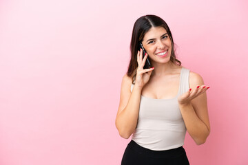 Young Italian woman isolated on pink background keeping a conversation with the mobile phone with someone