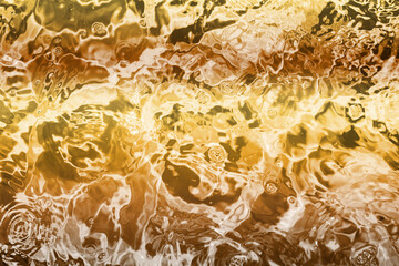 Blurred transparent Yellow Gold colour clear calm water surface texture with splashes and bubbles....