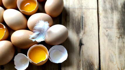 Fresh chicken eggs are collected in a pile. A broken egg.