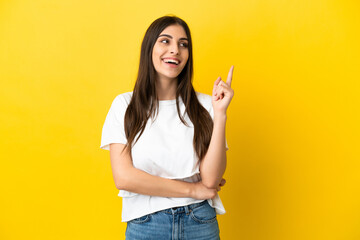 Young caucasian woman isolated on yellow background pointing up a great idea