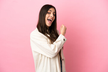 Young caucasian woman isolated on pink background celebrating a victory