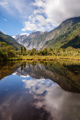 Naklejka na ściany i meble Peters Pool, a mirror lake, reflecting the snow capped mountains at Franz Josef on the South Island of New Zealand