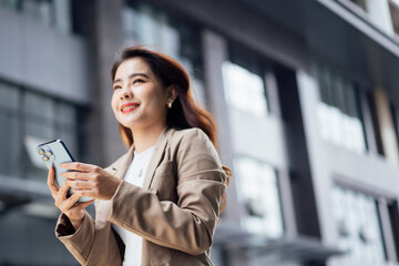 Fototapeta premium Business woman talking on mobile phone and smiling, Happy business woman, business woman with mobile phone in hand looking at camera, Image of pretty smiling woman in fashion