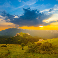 Fototapeta na wymiar green mountain valley at the dramatic sunset